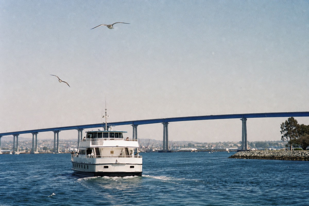 Sightseeing boat on San Diego Bay with the Coronado Bridge arcing behind it