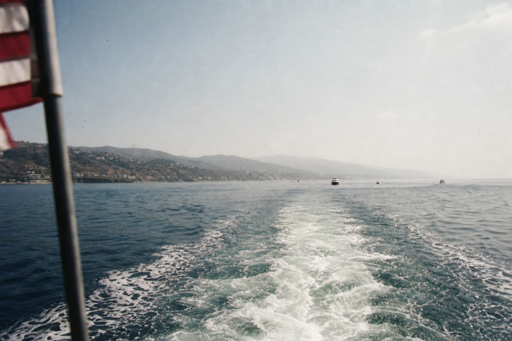 Stern wake pointing south along the hazy Baja coastline on a cruise route out of San Diego