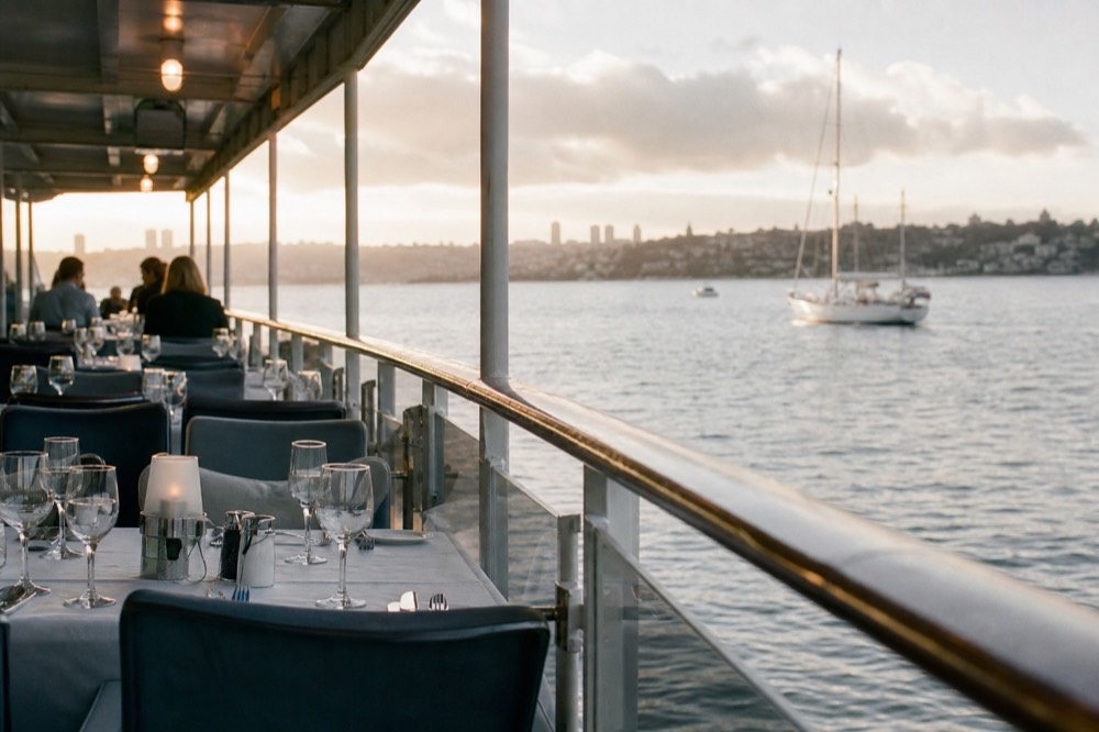 Table settings and evening water views aboard a San Diego dinner ship, late-morning light
