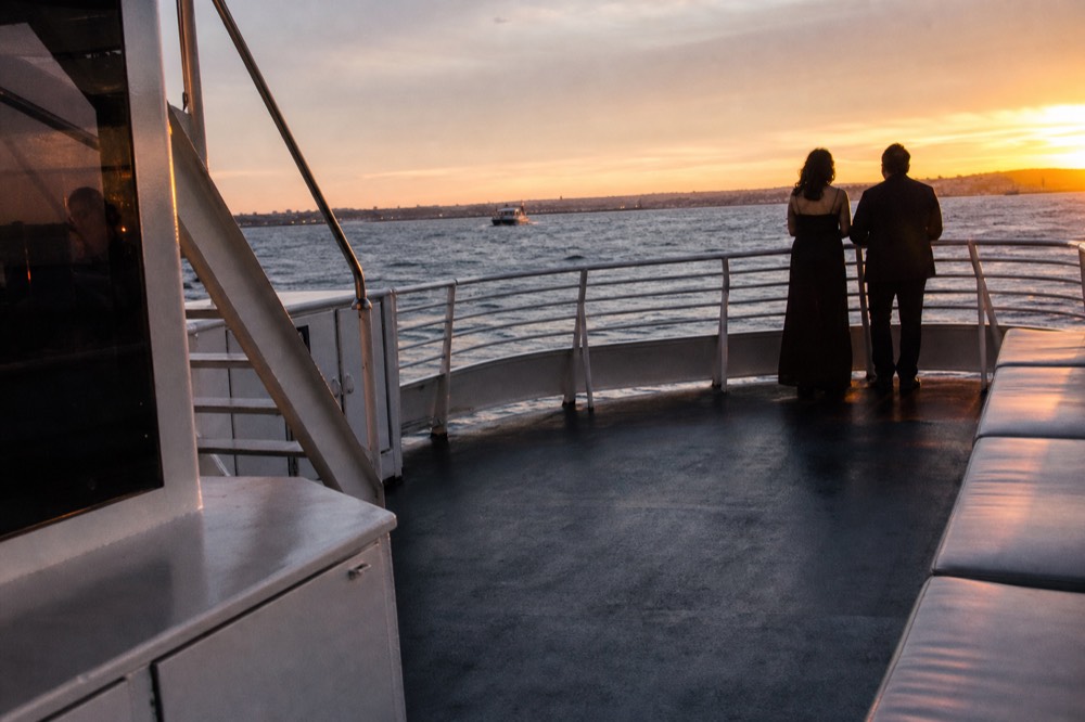 Evening outfits and deck details on a dusk cruise on San Diego Bay at golden hour, long shadows and warm low light