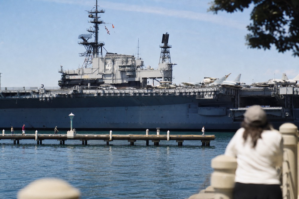 The massive gray aircraft carrier museum ship on the San Diego waterfront, late-morning light