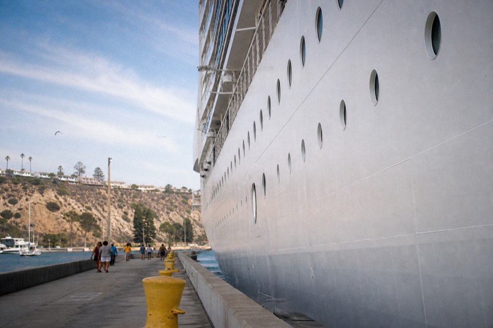 White cruise ship hull towering over the pier walkway at the San Diego cruise terminal on Harbor Drive