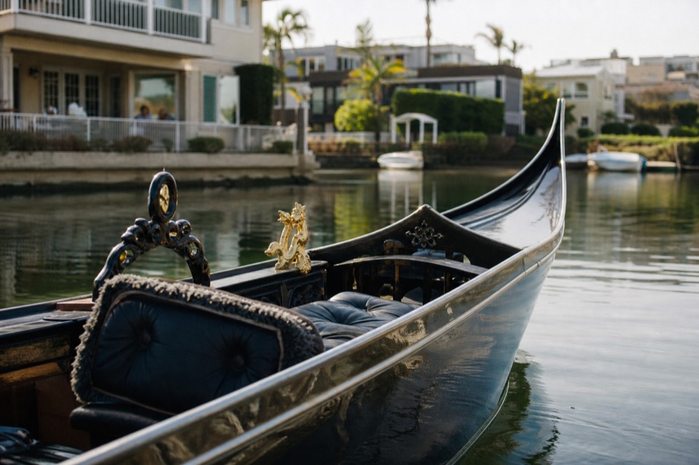 A black Venetian gondola in the calm canals of the Coronado Cays, shallow depth of field, textures sharp