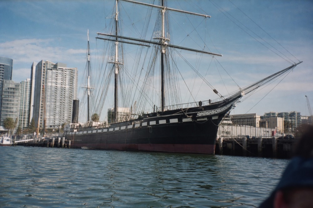 Iron-hulled 1863 tall ship moored on the Embarcadero, seen from the water on a San Diego harbor cruise