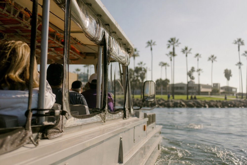 A boxy amphibious sightseeing vehicle around San Diego's palm-lined waterfront, shallow depth of field, textures sharp