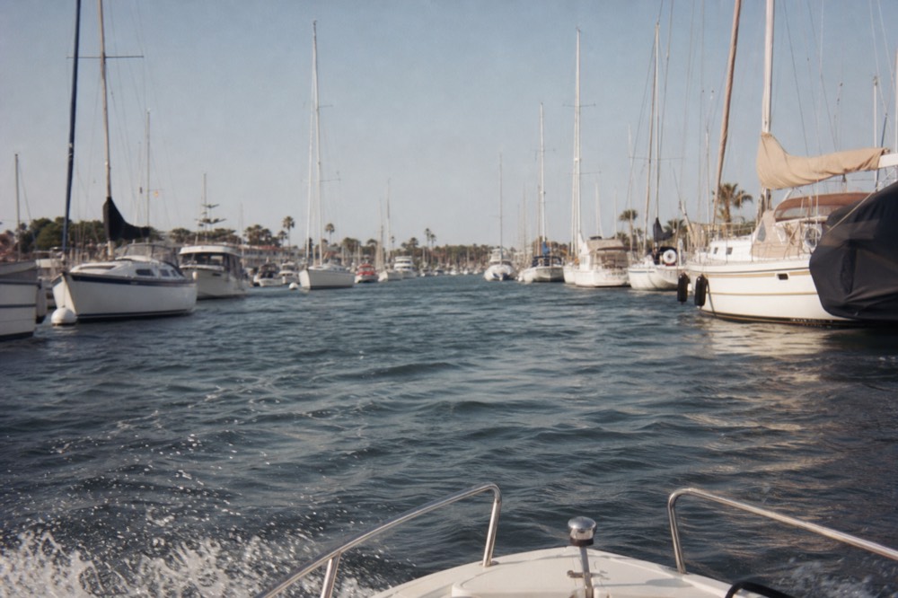 View forward from a small boat running the San Diego harbor channel at speed past moored yachts
